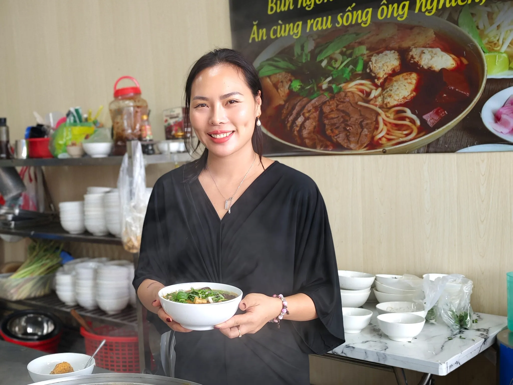 Cô Lam tại bếp Quán Lam, bưng tô bún riêu cua